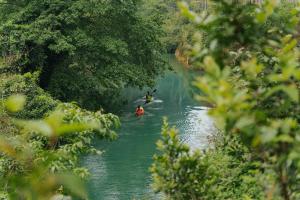 two people kayaking on a river with trees at Blue Diamond Retreat in Vực Trô