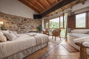 a bedroom with a large bed and a bath tub at Carbayu Senda del Oso in Proaza