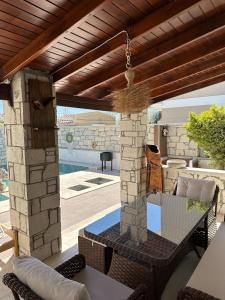 a patio with a table and a stone pillar at Eos in Çeşme