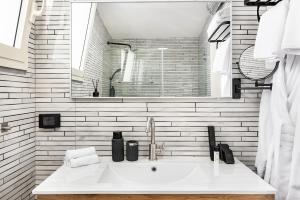 a white bathroom with a sink and a mirror at One Apartments TLV in Tel Aviv