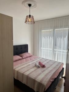 a bedroom with a bed with pink sheets and a window at Eos in Çeşme