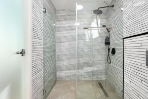 a bathroom with a shower with a glass door at One Apartments TLV in Tel Aviv