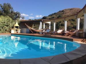 a swimming pool with chairs and a gazebo at Villa SERENA in Sarrola-Carcopino