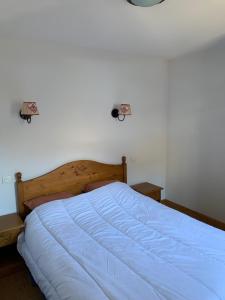 a bedroom with a large bed with a blue comforter at Chalet des Evettes in Flumet