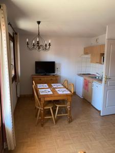 a kitchen with a wooden table and a kitchen with a refrigerator at Chalet des Evettes in Flumet +15 photos