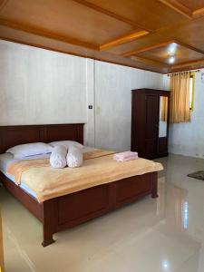 a bedroom with a bed with two pillows on it at laroka hotel in Waha
