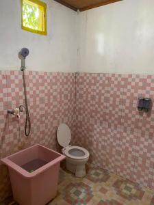a bathroom with a toilet and a bath tub at laroka hotel in Waha