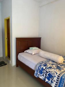 a bedroom with a bed with a wooden headboard at laroka hotel in Waha