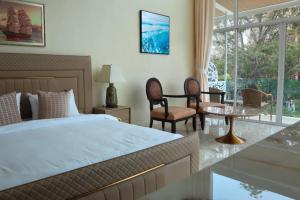 a bedroom with a bed and a table and chairs at Ta Yai Beach Resort in Pattaya