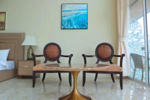 a room with a table and two chairs and a bed at Ta Yai Beach Resort in Pattaya