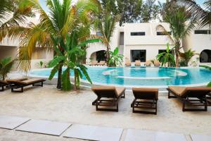 a swimming pool with chairs and a building at Kano Boutique Hotel Paje in Paje