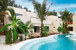 a resort with a swimming pool and palm trees at Kano Boutique Hotel Paje in Paje