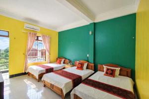 two beds in a room with green and yellow walls at Thuỳ Dương Hotel Cao Bằng in Bảo Lạc