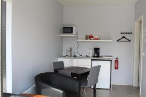 a kitchen with a table and chairs in a room at Systrakot - Studio Apartments in Talknafjordur +8 photos