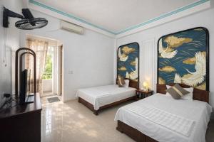 a bedroom with two beds and a tv in it at Thuỳ Dương Hotel Cao Bằng in Bảo Lạc