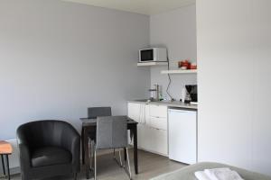 a small kitchen with a table and a chair at Systrakot - Studio Apartments in Talknafjordur