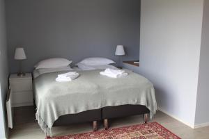 a bedroom with a bed with two towels on it at Systrakot - Studio Apartments in Talknafjordur