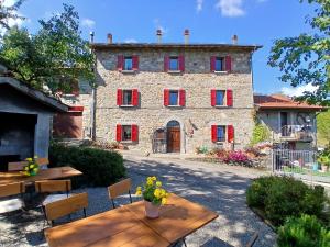 a large stone building with red shutters on it at Agri B&B Ca' Gennara in Porretta Terme