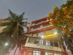 a tall building with a palm tree in front of it at Sahara Inn in Mumbai