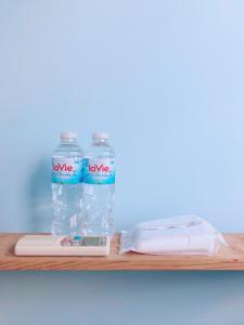 two bottles of water sitting on a wooden shelf at Bot Bien Homestay in Mui Ne