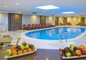 a hotel room with a swimming pool and fruit on tables at Özkaymak Select Resort Hotel - Ultra All Inclusive in Alanya