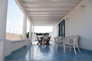 a patio with chairs and a table on a balcony at Villa Ilaria in Marzamemi