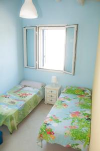 a bedroom with two twin beds and a window at Villa Ilaria in Marzamemi