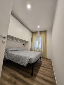a bedroom with a bed in a white room at Lovely Corner 2 in Porto Santo Stefano
