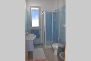 a blue bathroom with a toilet and a sink at Villa Ilaria in Marzamemi +11 photos