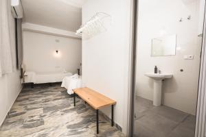 a bathroom with a sink and a toilet and a bench at Hotel Rural Macondo in Trujillanos