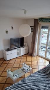 a living room with a tv and a bed and a table at Private Ideal Apartment in Fribourg