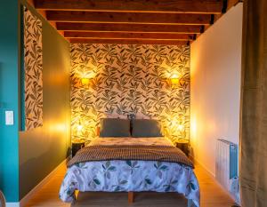 a bedroom with a bed and two lights on the wall at Le perchoir in Cuverville