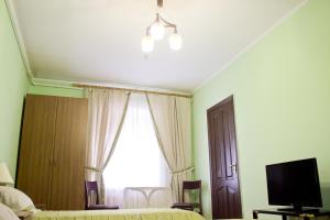 a bedroom with a bed and a window and a tv at Hotel Uyut in Kremenchuk