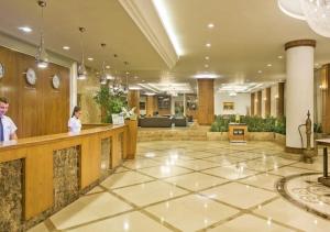 a lobby of a hotel with two people standing at a counter at Özkaymak Select Resort Hotel - Ultra All Inclusive in Alanya +42 photos