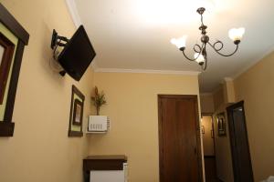 ein Zimmer mit einem Fernseher an der Wand und einer Tür in der Unterkunft Hostal Rocio in Sanlúcar la Mayor + 73 Fotos
