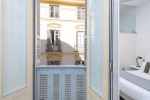 a room with a view of a building through a door at Apartamentos Calle Larios in Málaga +127 photos