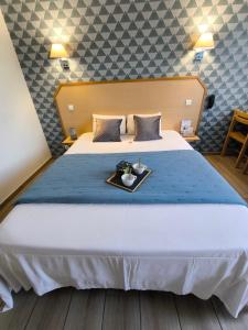 a hotel room with a bed with a tray of food on it at Hôtel Le Laury's-hôtel calme proche de Rodez avec parking privé gratuit-Arrivée après 20h possible via borne automatique in Onet le Château