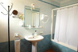 ein Badezimmer mit Waschbecken und Spiegel in der Unterkunft Hostal Rocio in Sanlúcar la Mayor