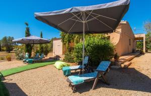 a patio with two chairs and an umbrella at Cas Nets in Llucmajor