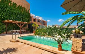 ein Swimmingpool im Garten mit einem Sonnenschirm in der Unterkunft Es Regaro in Capdepera