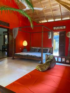 a bedroom with a bed and a red wall at Dragon-Fly Home Hikka in Dodanduwa +124 photos