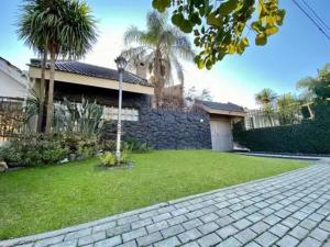 a house with a brick driveway in front of a yard at Gravensteen Urca in Córdoba