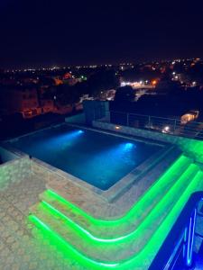 a swimming pool at night with green lights at Hôtel Résidence Ngary in Thiès