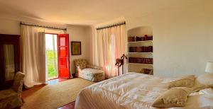a bedroom with a bed and a window and a chair at Hacienda Don Rodrigo in Alcalá de Guadaira