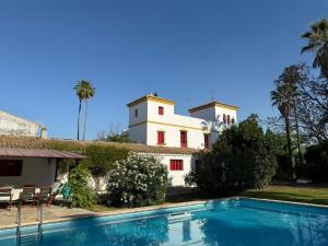 a house with a swimming pool in front of a building at Hacienda Don Rodrigo in Alcalá de Guadaira