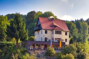 a large house with a red roof on a hill at Pension Zum Talwächter im Sandsteinidyll in Rathen