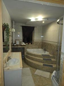 a large bathroom with a tub and a sink at Przytulisko Dom na wyłączność in Biały Dunajec