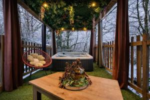 a gazebo with a hot tub and a table at La Cabane Enchanteresse in Illoud