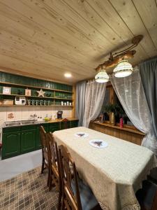 a dining room with a table and some green cabinets at Przytulisko Dom na wyłączność in Biały Dunajec