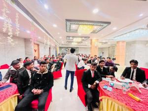 a group of people sitting at tables in a room at Hotel The Coal in Alīgarh